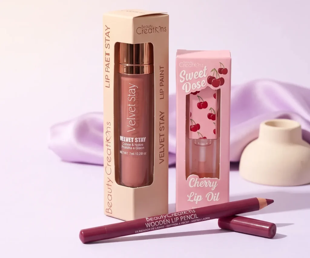 Beauty Creations Velvet Stay Lip Paint, Sweet Dose Cherry Lip Oil and Wooden Lip Pencil on a soft lilac background